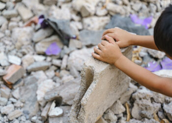 Enfant dans décombres de pierres