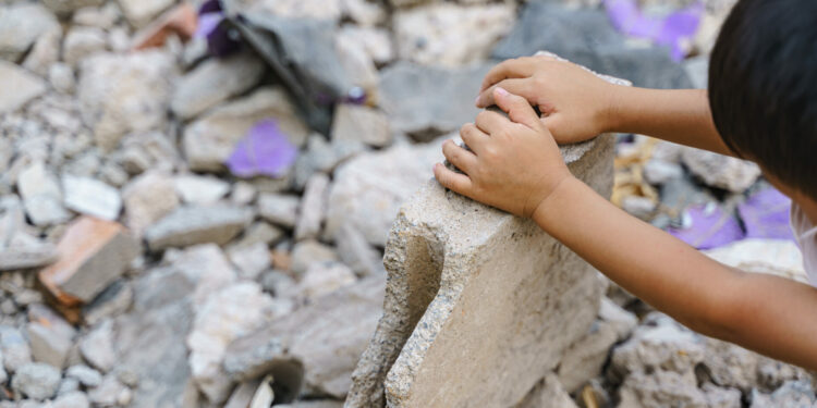 Enfant dans décombres de pierres