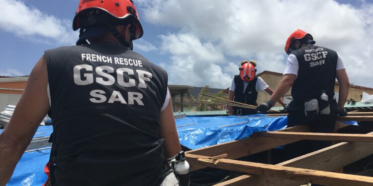 Équipe de pompiers du GSCF intervenant lors d'une mission de secours humanitaire en zone sinistrée, apportant aide et soutien aux victimes de catastrophes.